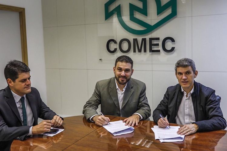 Foto do presidente com o gerente assinando um documento no gabinete do presidente da comec