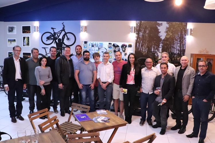 Foto com todos que participaram da reunião em pé pousando para foto