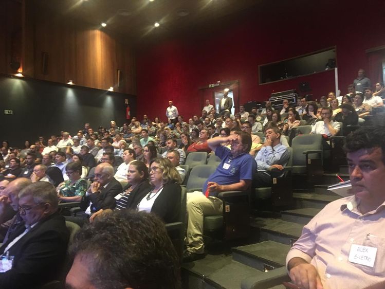 Foto do auditório do Sesc com pessoas sendas na platéia assistindo o evento
