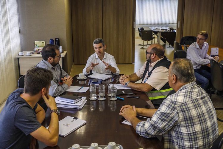 Foto da reunião na Comec com o presidente sentado na mesa com o secretario de sao jose dos pinhais e demais integrantes da equipe