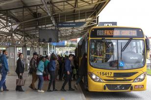 Foto de pessoas entreando em um ônibus