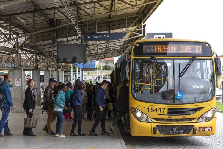 Foto de pessoas entreando em um ônibus