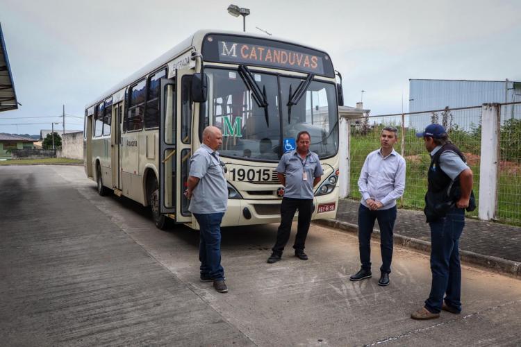 Foto gilson santos conversando com motoristas em frente ao ônibus